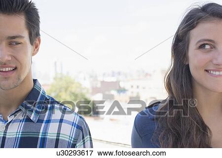 Stock Photo - Young couple looking sideways. Fotosearch