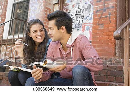 Young couple reading book and doing crossword View Large Photo Image Stock Photo - Young couple reading book and doing crossword. Fotosearch