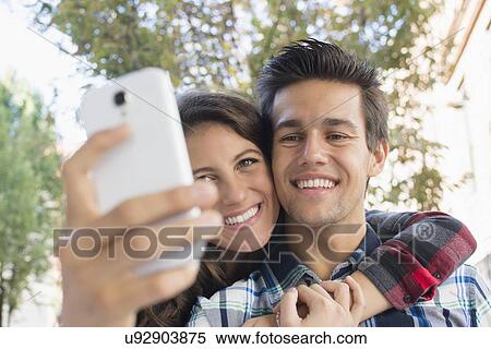 Stock Photography - Young couple taking selfie. Fotosearch