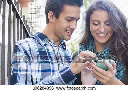 Stock Photograph - Young couple texting . Fotosearch