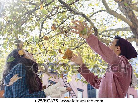 Young couple throwing autumn leaves View Large Photo Image Stock Photography - Young couple throwing autumn leaves. Fotosearch