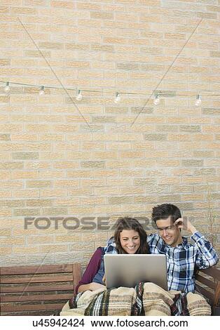 Young couple using laptop on roof View Large Photo Image Picture - Young couple using laptop on roof. Fotosearch