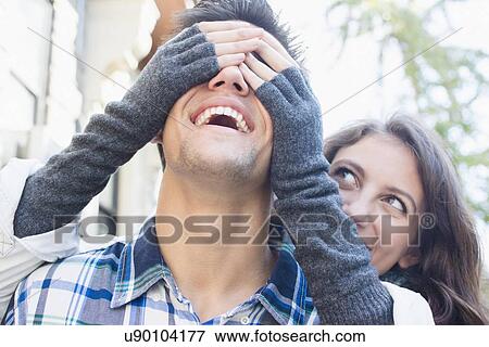 Young woman covering her boyfriend's eyes View Large Photo Image Stock Photo - Young woman covering her boyfriend's eyes. Fotosearch