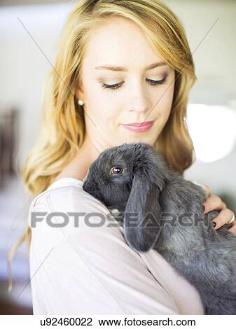 Young woman stroking her bunny View Large Photo Image Stock Image - Young woman stroking her bunny. Fotosearch
