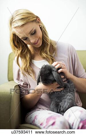 Young woman stroking rabbit View Large Photo Image Stock Image - Young woman stroking rabbit. Fotosearch