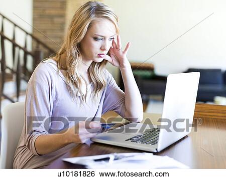 Young woman using laptop at table View Large Photo Image Stock Photograph - Young woman using laptop at table. Fotosearch
