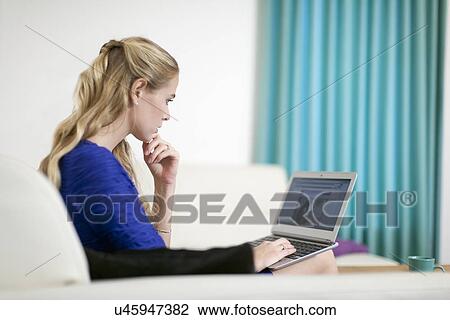 Stock Image - Young woman using laptop . Fotosearch