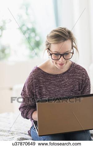 Young woman using laptop View Large Photo Image Stock Photo - Young woman using laptop. Fotosearch