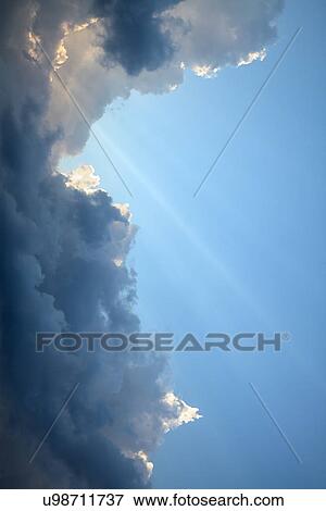 Stock Photo - Suns rays through clouds. Fotosearch