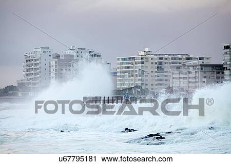 Stock Image - Waves crashing against sea wall. Fotosearch