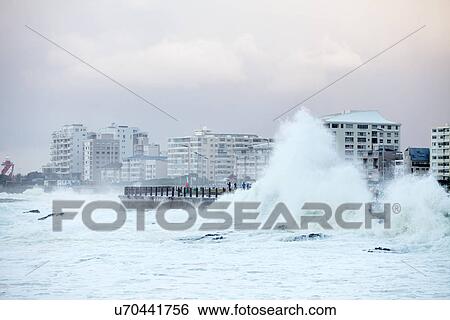 Stock Photograph - Waves crashing against sea wall. Fotosearch