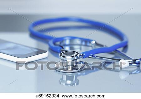 Acoustic stethoscope and smartphone on office desk View Large Photo Image Picture - Acoustic stethoscope and smartphone on office desk. Fotosearch