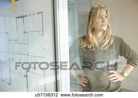 Architect looking at plans taped to glass wall View Large Photo Image Stock Image - Architect looking at plans taped to glass wall. Fotosearch