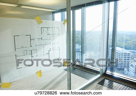 Architectural plans taped to glass wall of empty room View Large Photo Image Stock Photograph - Architectural plans taped to glass wall of empty room. Fotosearch