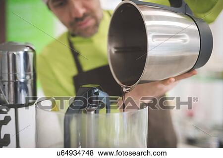 Baker pouring liquid into mixer View Large Photo Image Stock Photo - Baker pouring liquid into mixer. Fotosearch