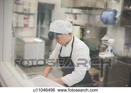 Baker rolling dough in kitchen View Large Photo Image Stock Photograph - Baker rolling dough in kitchen. Fotosearch