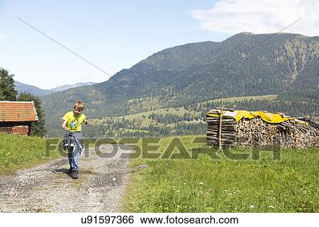 "Boy running along dirt track in mountain landscape, Eckbauer bei Garmisch, Bavaria, Germany" View Large Photo Image Stock Photograph - "Boy running along dirt track in mountain landscape, Eckbauer bei Garmisch, Bavaria, Germany". Fotosearch