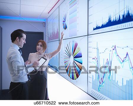 Business colleagues discussing graphs on screen in meeting room View Large Photo Image Stock Image - Business colleagues discussing graphs on screen in meeting room. Fotosearch