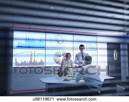 Business colleagues discussing graphs on screen in meeting room View Large Photo Image Stock Image - Business colleagues discussing graphs on screen in meeting room. Fotosearch
