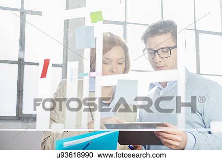 Businessman and woman looking at digital tablet View Large Photo Image Stock Image - Businessman and woman looking at digital tablet. Fotosearch