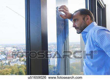 "Businessman leaning against office window gazing at Brussels cityscape, Belgium" View Large Photo Image Stock Photograph - "Businessman leaning against office window gazing at Brussels cityscape, Belgium". Fotosearch