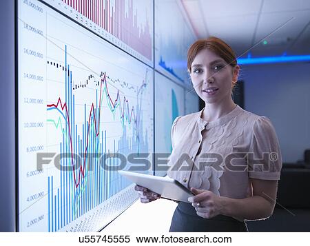 "Businesswoman holding digital tablet in front of graphs on screens, portrait" View Large Photo Image Stock Photography - "Businesswoman holding digital tablet in front of graphs on screens, portrait". Fotosearch