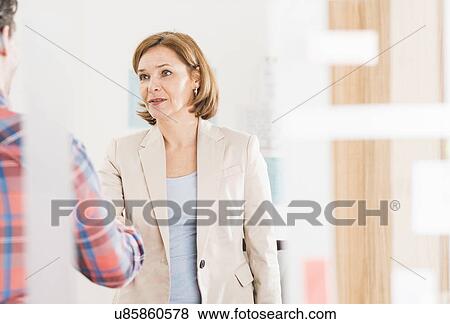 Businesswoman shaking hands with candidate in office View Large Photo Image Stock Photo - Businesswoman shaking hands with candidate in office. Fotosearch
