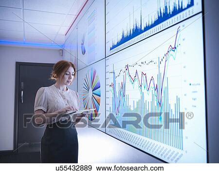 Businesswoman studying graphs on screen with digital tablet View Large Photo Image Stock Photo - Businesswoman studying graphs on screen with digital tablet. Fotosearch