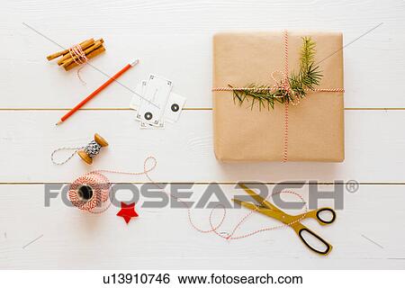 Stock Photograph - "Christmas gift, thread, scissors, cinnamon sticks, pencil, labels, pine needles". Fotosearch