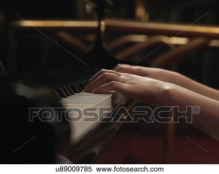 Stock Photography - Close up of girls hands playing piano keys. Fotosearch