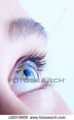 Stock Photo - Close up of teenage girls blue eye looking up. Fotosearch