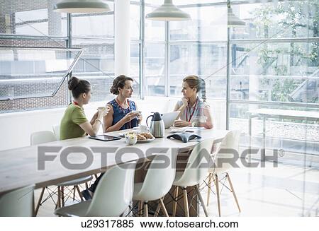 Stock Photography - Colleagues having breakfast meeting. Fotosearch