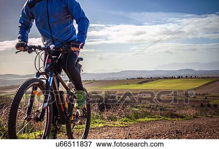 "Cropped close up of male mountain biker cycling up dirt track, Cagliari, Sardinia, Italy" View Large Photo Image Stock Photo - "Cropped close up of male mountain biker cycling up dirt track, Cagliari, Sardinia, Italy". Fotosearch