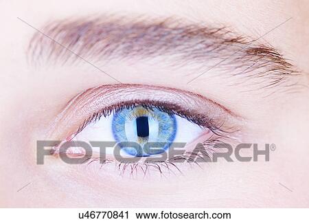 Stock Image - Cropped close up of teenage girls blue eye. Fotosearch