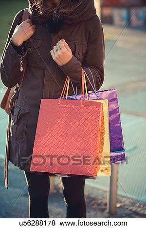 Cropped shot of mid adult woman on street with shopping bags View Large Photo Image Stock Photo - Cropped shot of mid adult woman on street with shopping bags. Fotosearch
