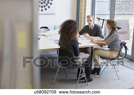 Design team meeting at conference table in office View Large Photo Image Stock Photo - Design team meeting at conference table in office. Fotosearch