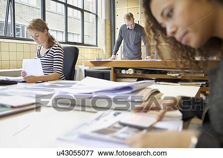 Stock Photo - Designers busy at work in creative office. Fotosearch