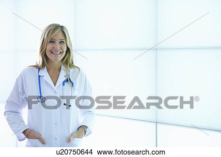 Doctor posing against backlit wall panel View Large Photo Image Picture - Doctor posing against backlit wall panel. Fotosearch