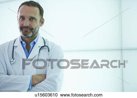 Doctor posing against backlit wall panel View Large Photo Image Stock Image - Doctor posing against backlit wall panel. Fotosearch