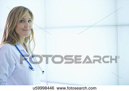 Doctor posing against backlit wall panel View Large Photo Image Stock Photograph - Doctor posing against backlit wall panel. Fotosearch