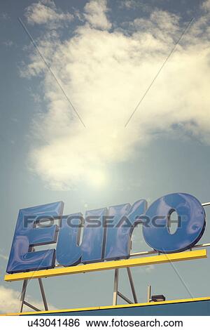 Stock Photograph - Euro sign against blue sky and clouds. Fotosearch