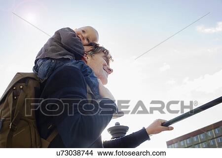 Father giving baby daughter shoulder ride in city View Large Photo Image Picture - Father giving baby daughter shoulder ride in city. Fotosearch