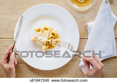 Female hands eating plate of ravioli stuffed with guinea fowl View Large Photo Image Stock Image - Female hands eating plate of ravioli stuffed with guinea fowl. Fotosearch