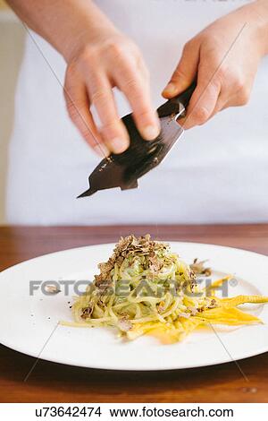 Female hands grating tartufo truffle onto plate of fresh pasta View Large Photo Image Picture - Female hands grating tartufo truffle onto plate of fresh pasta. Fotosearch