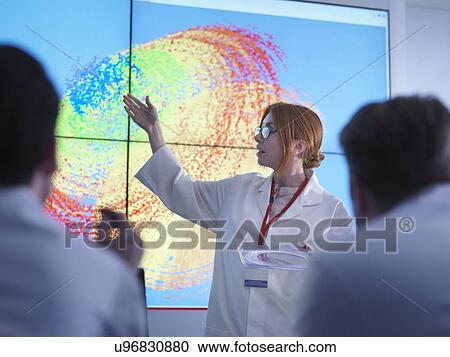Female scientist making presentation in front of graphical display of silicon wafer on screens View Large Photo Image Stock Image - Female scientist making presentation in front of graphical display of silicon wafer on screens. Fotosearch