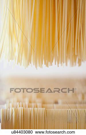 Stock Image - "Fresh artisan spaghetti drying, Tuscany, Italy". Fotosearch