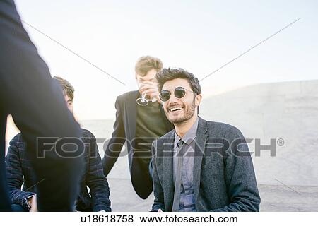 Friends drinking and laughing at party View Large Photo Image Stock Photo - Friends drinking and laughing at party. Fotosearch