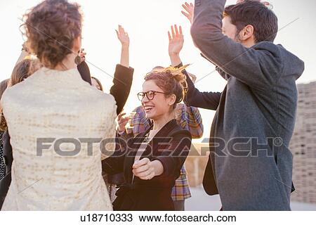 Stock Image - Group of friends dancing at party. Fotosearch