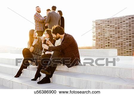 Stock Image - Group of friends drinking together at party. Fotosearch