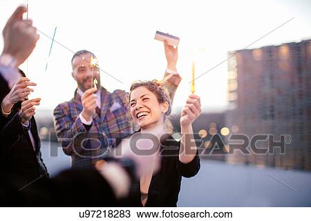 "Group of friends holding sparklers, at party" View Large Photo Image Stock Image - "Group of friends holding sparklers, at party". Fotosearch
